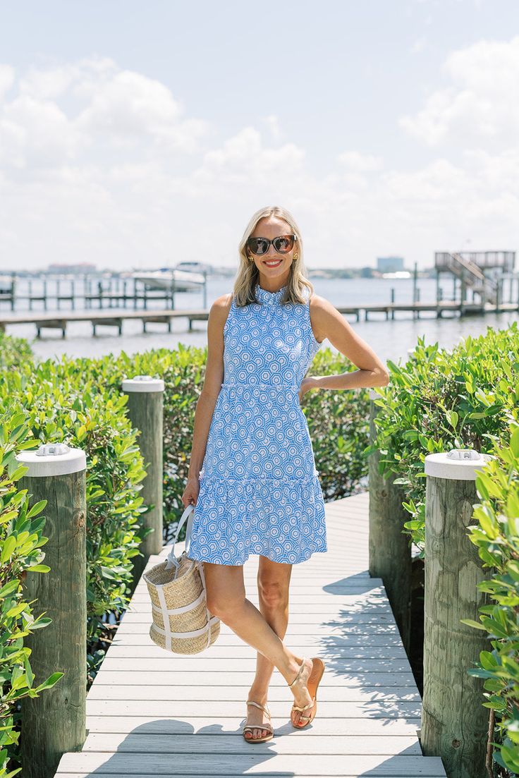 Introducing our vibrant Nicola Dress in the playful and summery Umbrella Sky print! Crafted from a lightweight stretchy cotton knit, this dress is as comfortable as it is stylish, making it the perfect choice for those warm sunny days. The standout feature of this dress is its charming ruffled collar and tiered skirt, adding a flirty and feminine touch to your look. Whether you're strolling along the beach or attending a garden party, this dress will make you feel effortlessly chic and carefree. Playful Floral Print Sundress For Summer, Playful Floral Sundress For Summer, Playful Summer Mini Dress For Garden Party, Spring Beachy Dresses For Garden Party, Beachy Dresses For Spring Garden Party, Spring Beachy Garden Party Dress, Cotton Beachy Dresses For Summer, Cotton Beachy Dress For Summer Outings, Playful Spring Sundress For Day Out