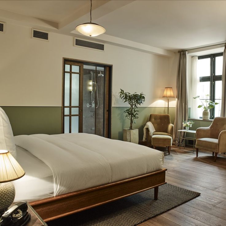 a large bed sitting inside of a bedroom on top of a hard wood flooring