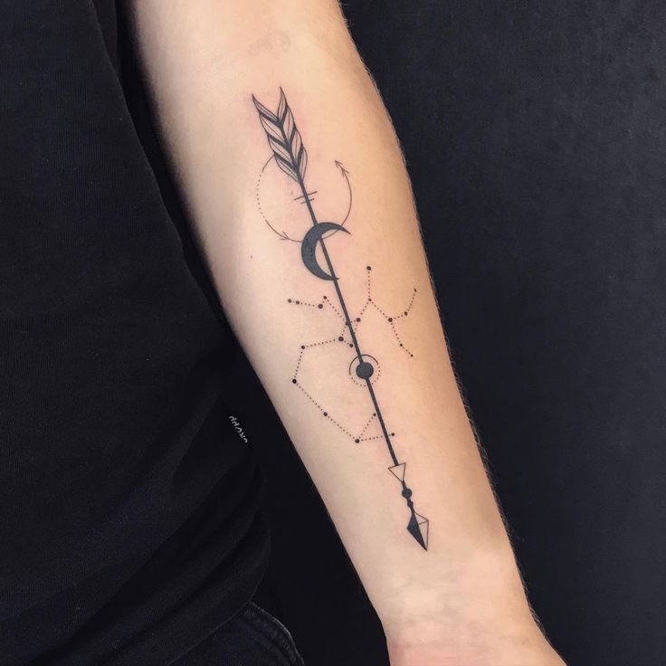 a man's arm with an arrow and moon tattoo on it, in black ink