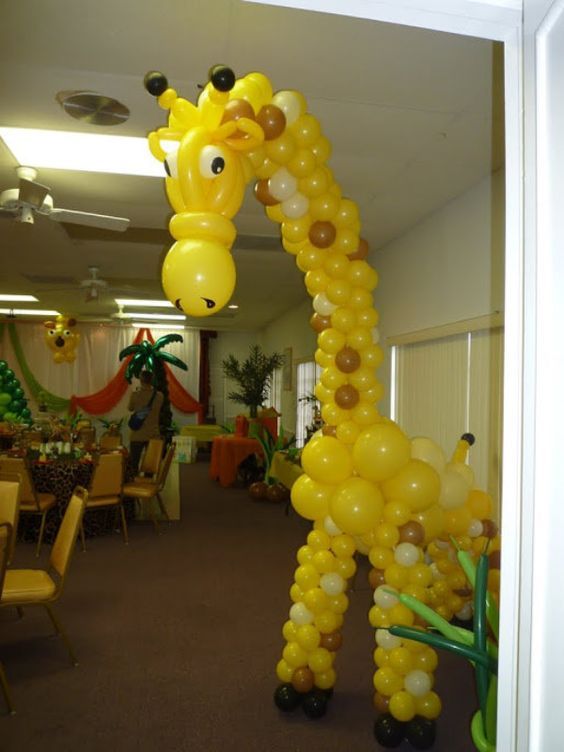 a giraffe balloon in the middle of a room filled with tables and chairs