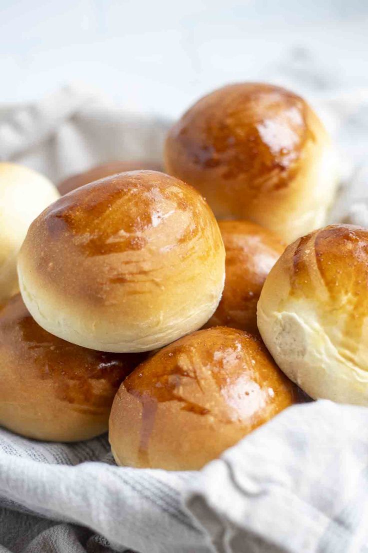 small rolls in a basket on top of a white cloth