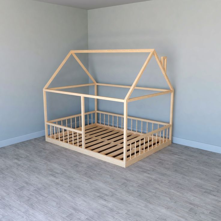 a wooden doll house bed in a room with light blue walls and wood flooring