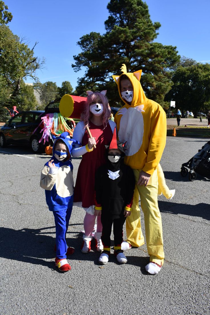 three people in costume standing next to each other on the street with trees in the background