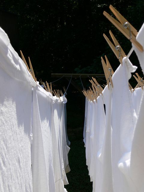 clothes are hung on the clothesline and drying in the sun with wooden pegs