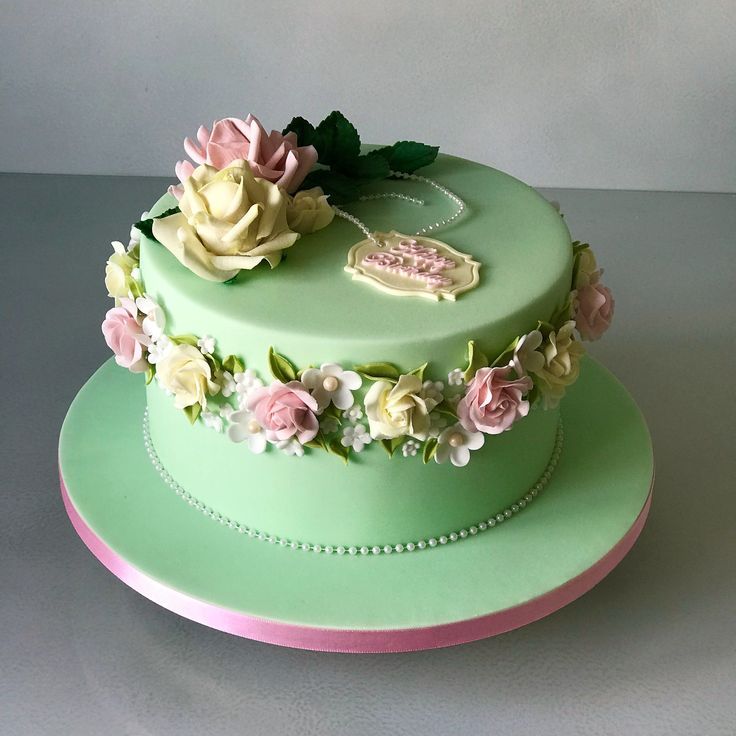 there is a green cake with flowers on it