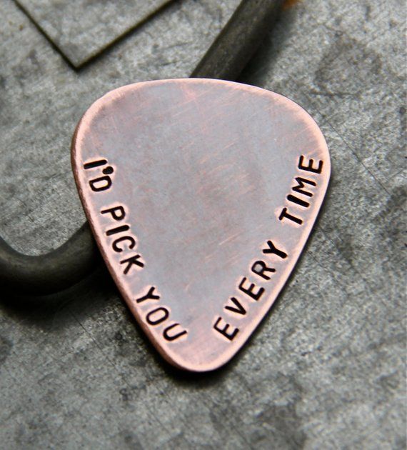 a metal guitar pick with the words i do rock you every time on it