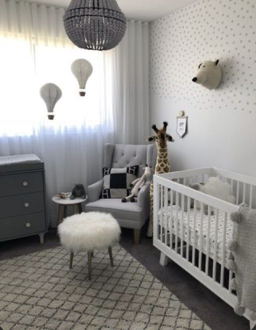 a baby's room with a giraffe in the corner and other furniture