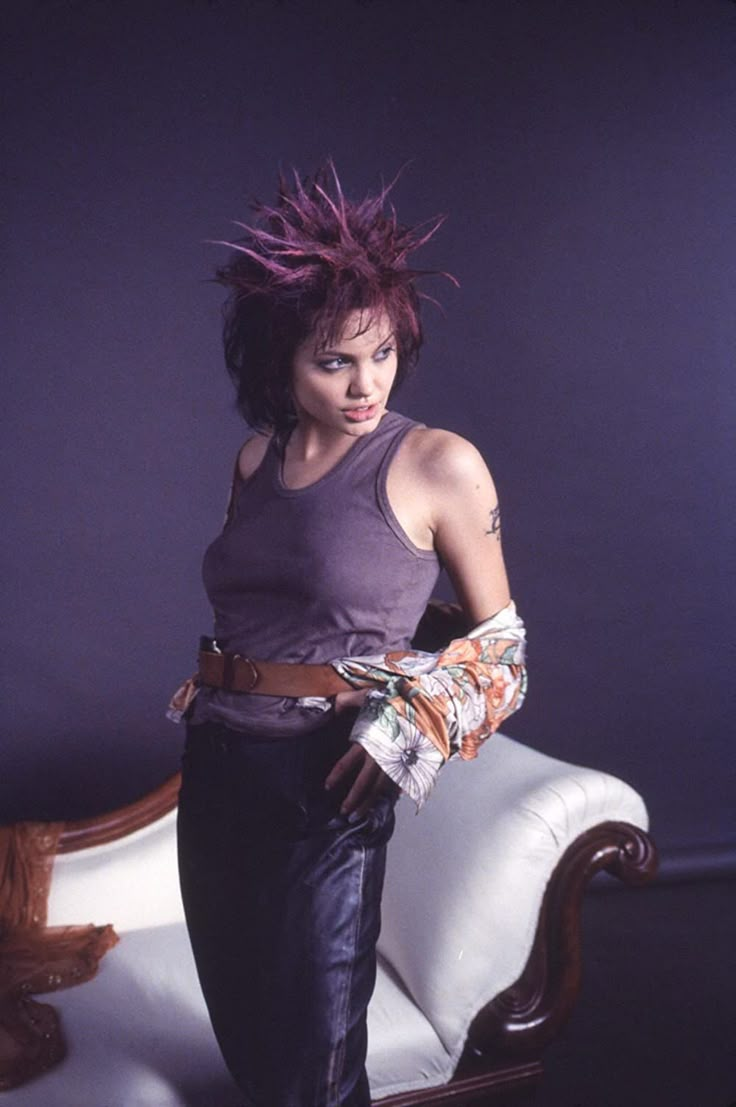 a woman with purple hair standing in front of a white couch