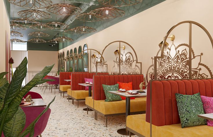 the interior of a restaurant with orange and yellow booths, pink chairs, and green plants