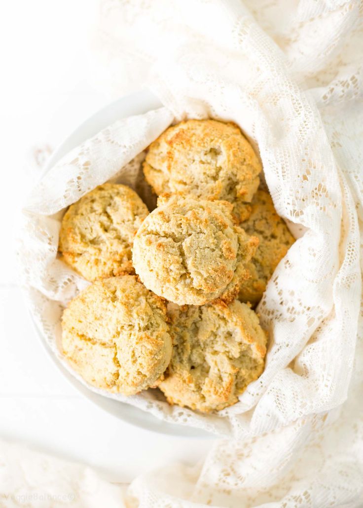 a white bowl filled with cookies on top of a table next to a cloth and napkin