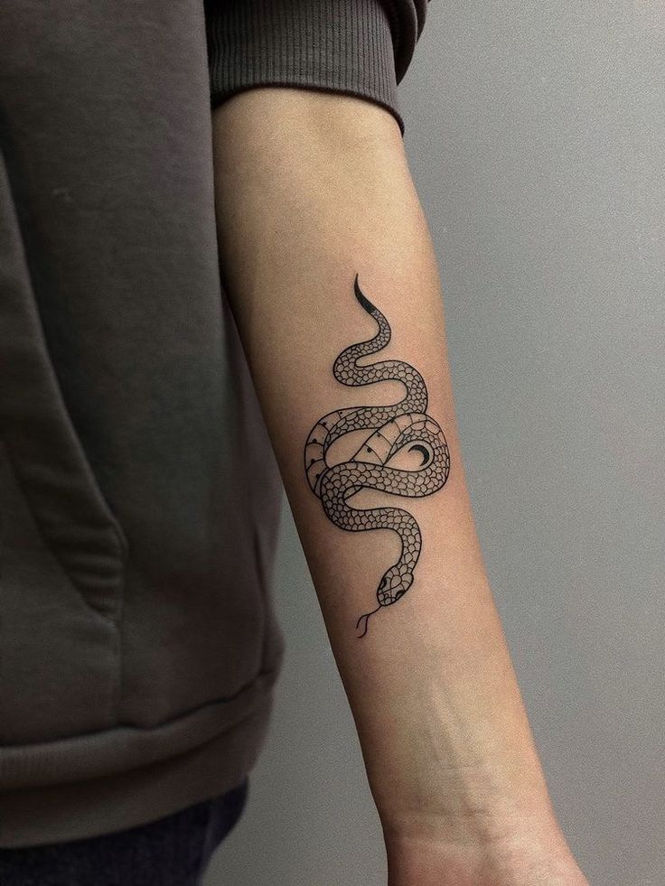 a woman's arm with a snake tattoo on it