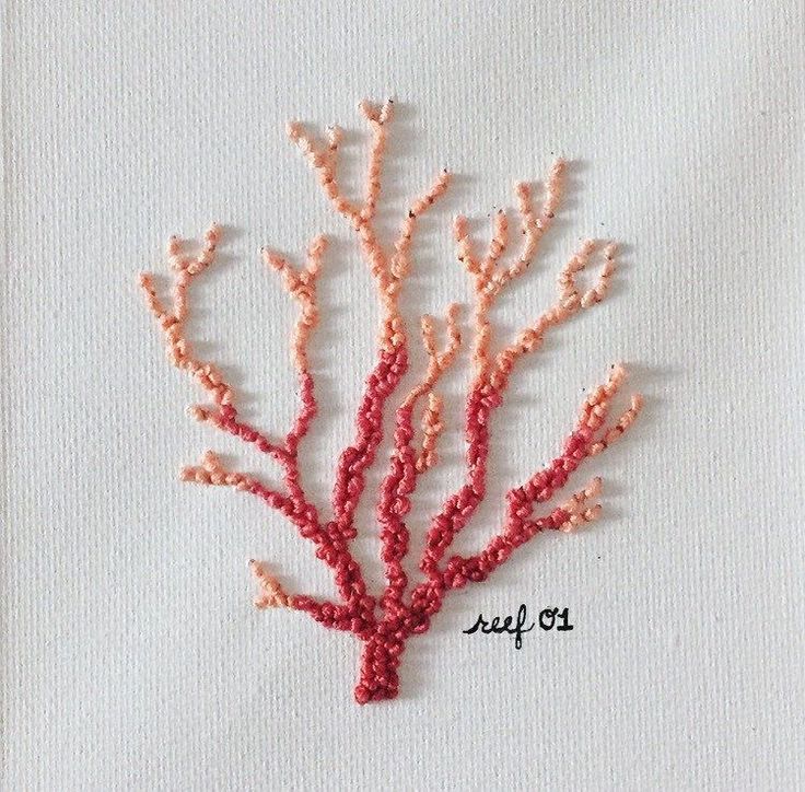 an embroidered coral is shown on a white piece of cloth with the word sea life written across it