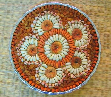 a bowl filled with lots of different types of flowers on top of a wooden table