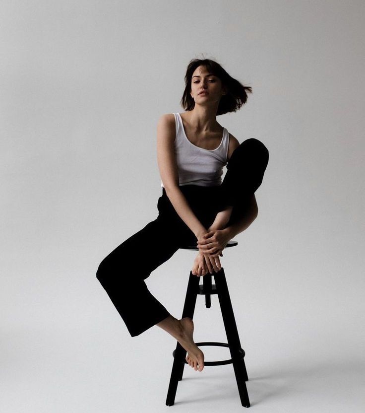 a woman sitting on top of a stool