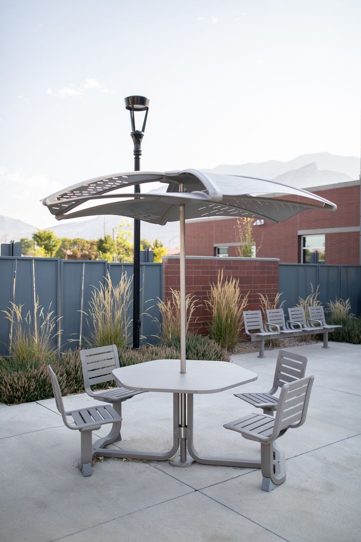 an outdoor table and chairs with an umbrella