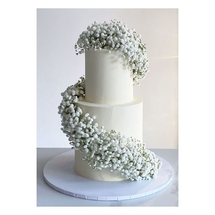 a three tiered cake with white flowers on top