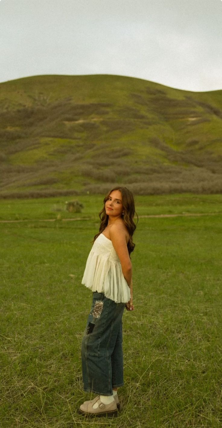 a woman standing in the middle of a field