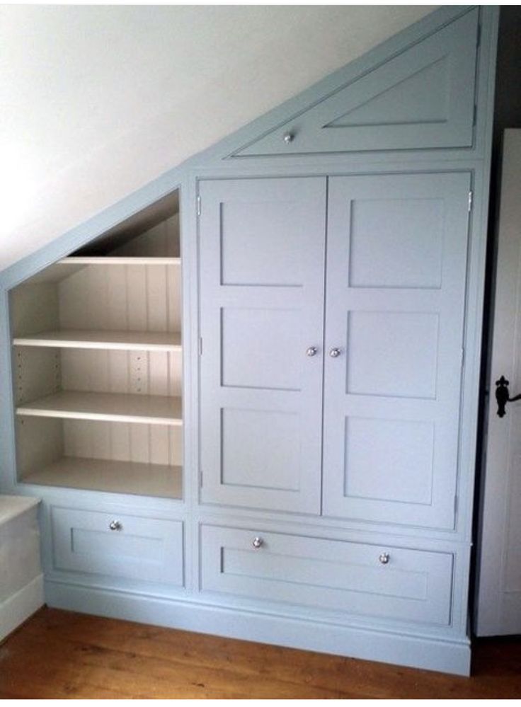 an attic bedroom with built in bookshelves and cabinets