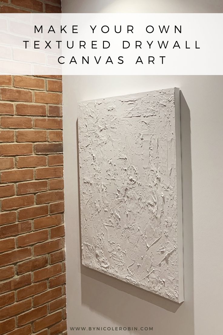 a white painting hanging on the wall with text overlay that reads make your own textured drywall canvas art