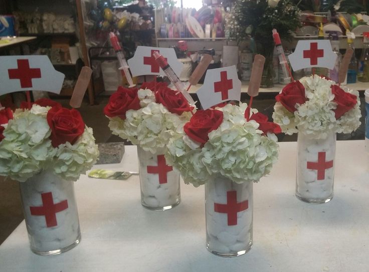 four vases with flowers in them are decorated with red and white crosses on sticks