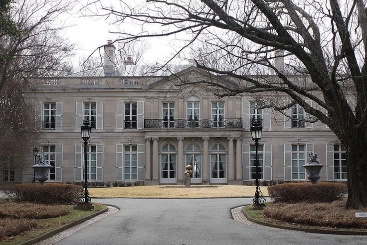 a large building with lots of windows next to a tree and street light in front of it