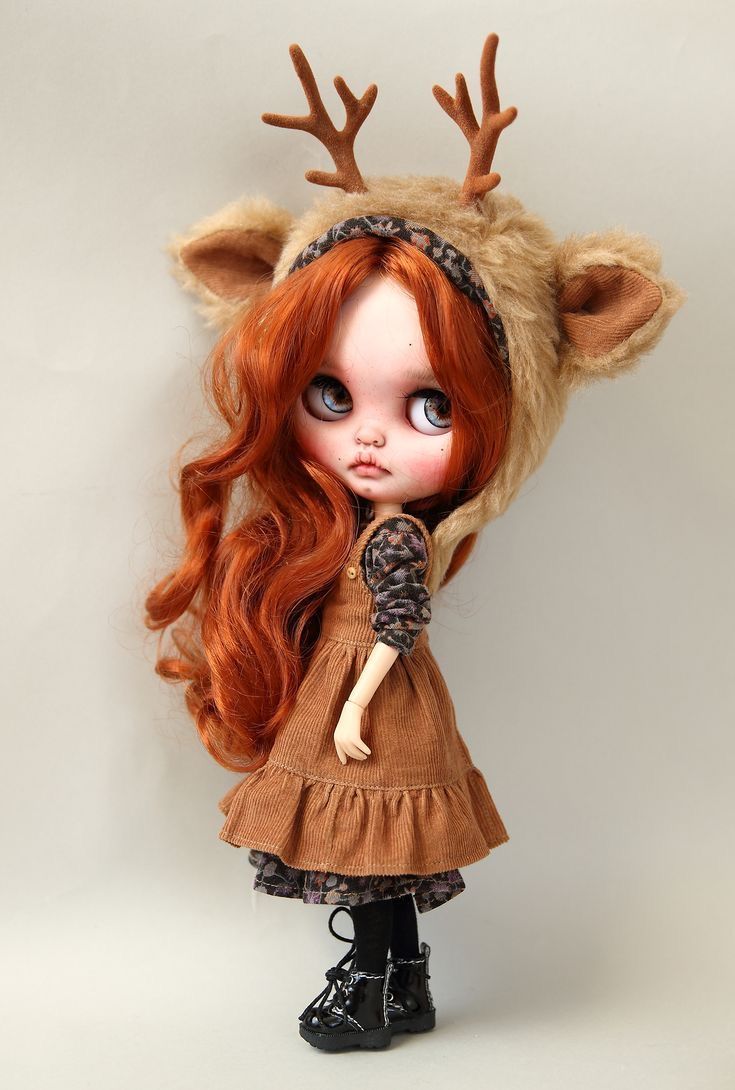 a doll with long red hair wearing a deer hat