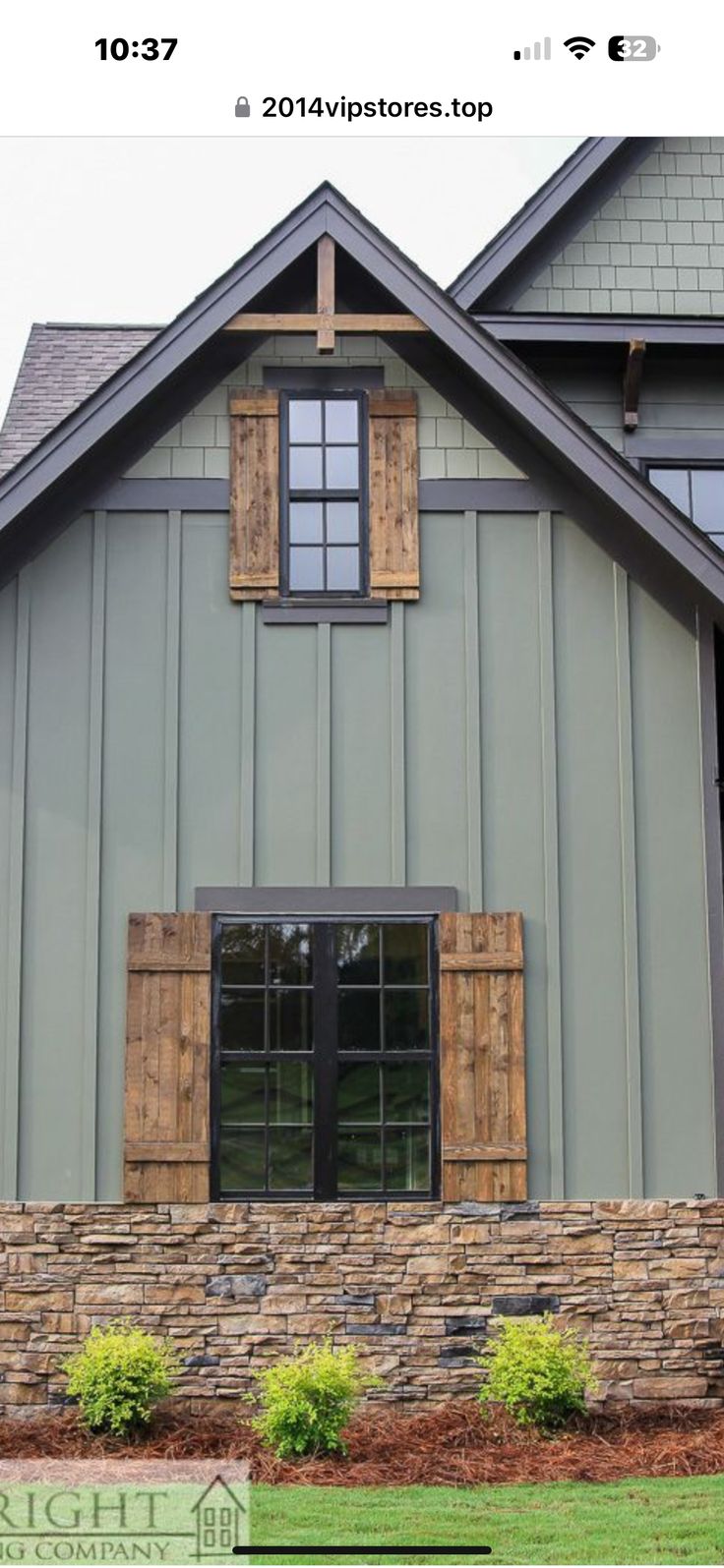 a large gray house with wooden shutters and windows