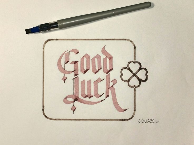 a drawing of a good luck and clover on paper with a pen next to it