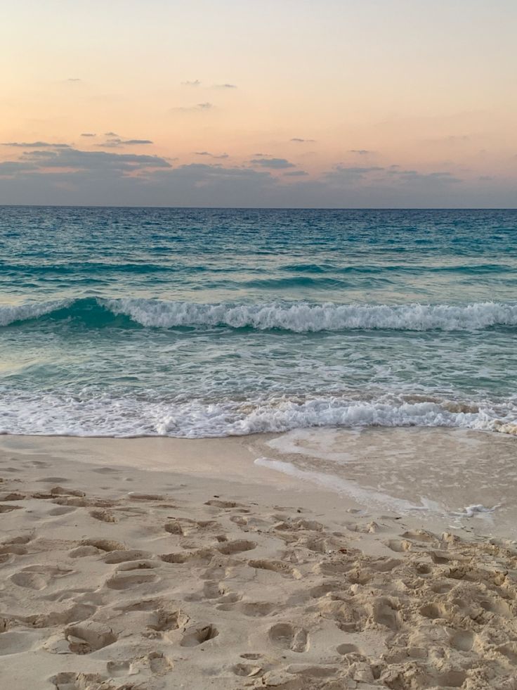 the ocean waves are coming in from the shore and there is sand on the beach