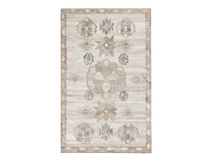 a white rug with an intricate design on the front and back side, in neutral tones