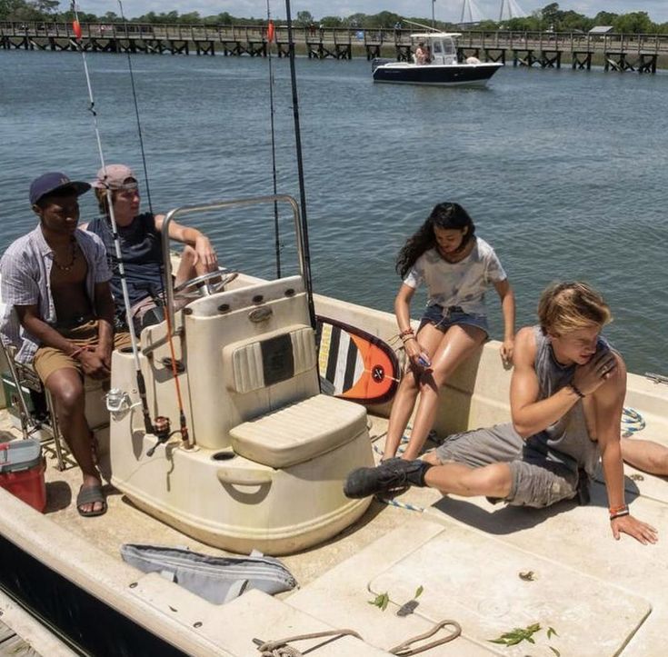 four people sitting on the back of a boat