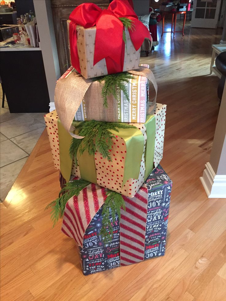 a stack of wrapped presents sitting on top of a wooden floor