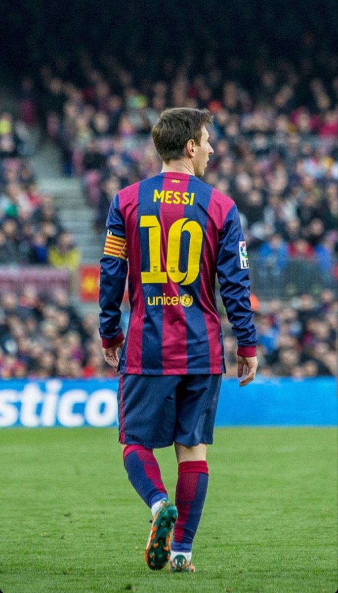 a soccer player is walking on the field in front of a large group of people