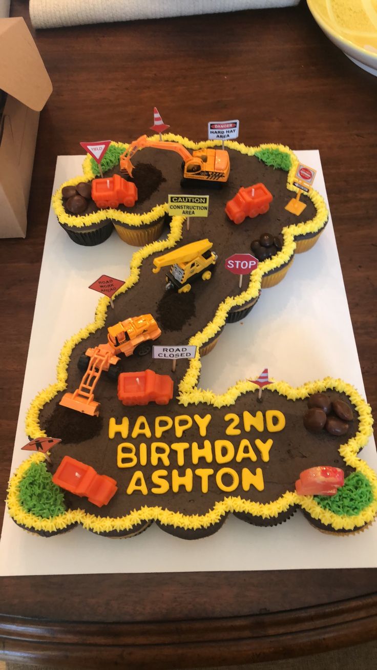 a birthday cake shaped like the number 5 with construction vehicles on it, sitting on top of a table