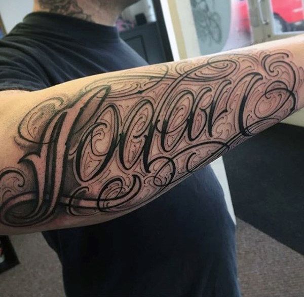 a man's arm with the word tattoo on it and his name written in cursive writing