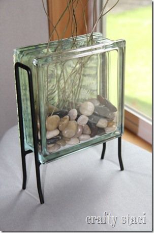 a glass container with rocks and plants in it