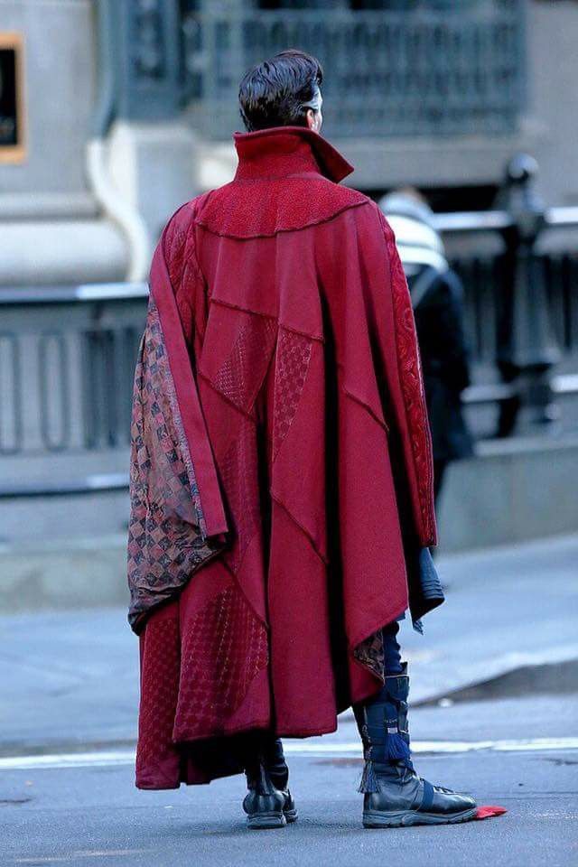 a man in a red coat is walking down the street