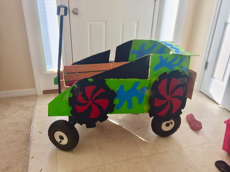 a homemade toy truck made out of cardboard with wheels and flowers on the front wheel