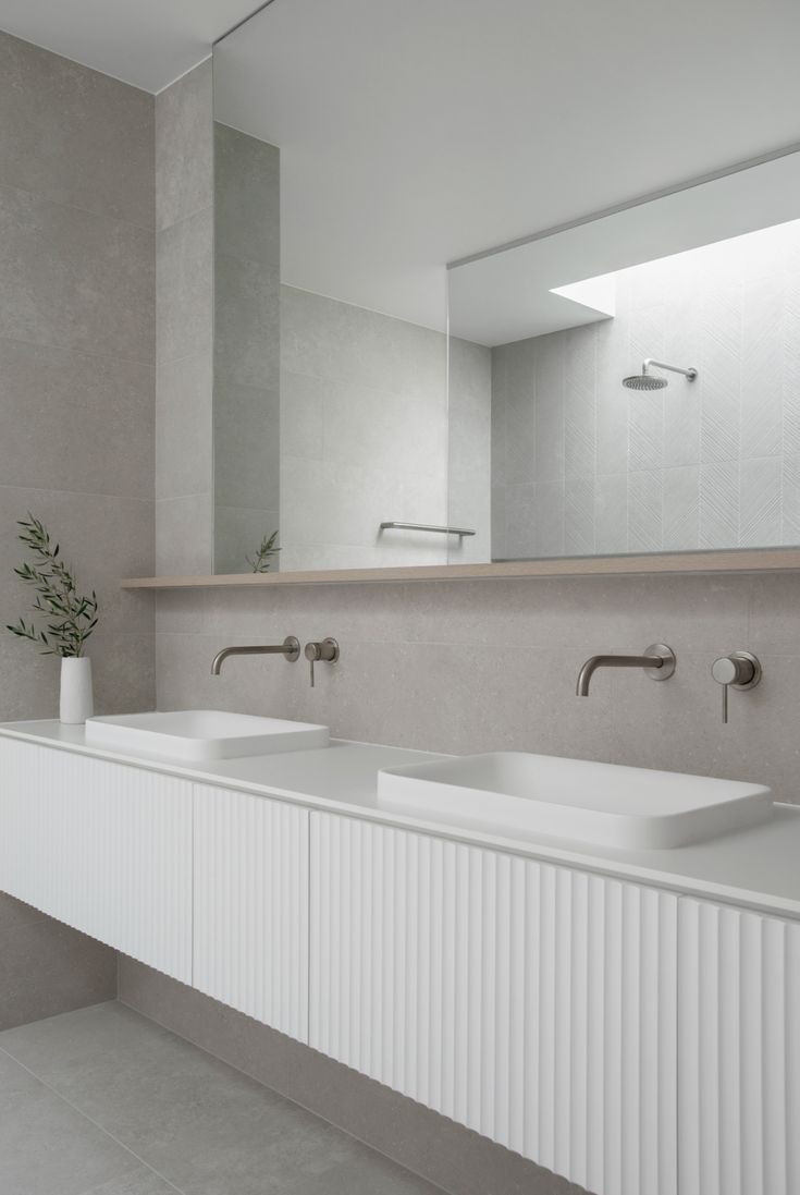 a bathroom with two sinks and a large mirror