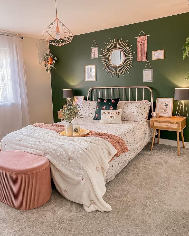 a bedroom decorated in green and pink with pictures on the wall above the headboard