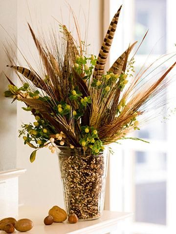 a vase filled with lots of flowers sitting on top of a white counter next to rocks