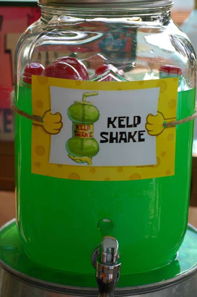 a jar filled with jelly beans sitting on top of a green table next to a sign that says keld shake