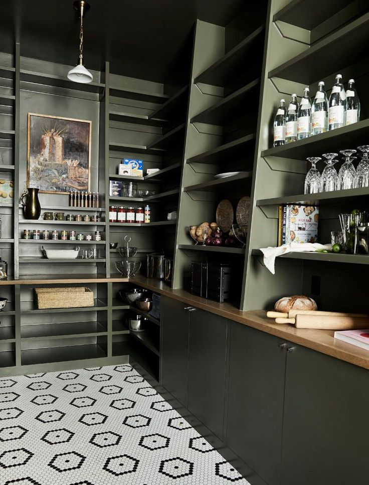 a kitchen with lots of shelves filled with bottles and glasses on top of each shelf