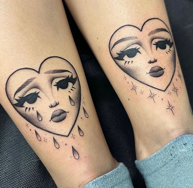 two heart shaped tattoos with faces and stars on their legs, one has tears coming from the other's eyes