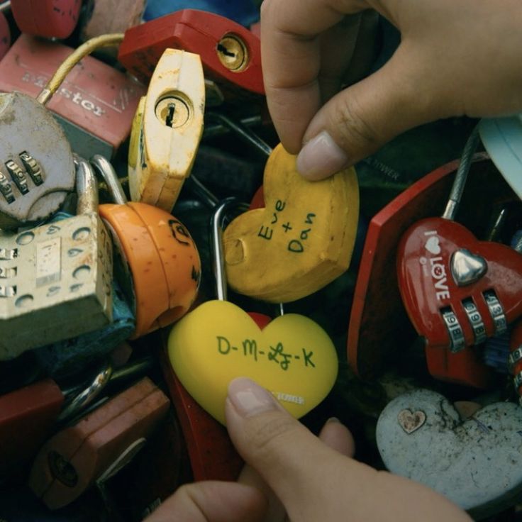 someone is holding a heart shaped padlock in front of many other locks and shacks