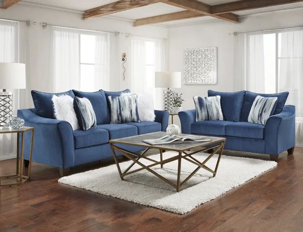 a living room with blue couches and pillows