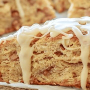 a close up of some food on a plate with white icing and cinnamon rolls