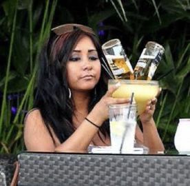 a woman sitting at a table with a drink in her hand