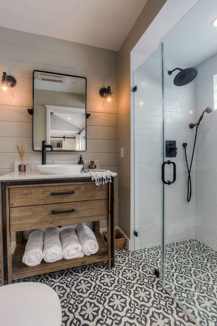 a bathroom with a sink, toilet and shower stall in the corner next to a stand up shower