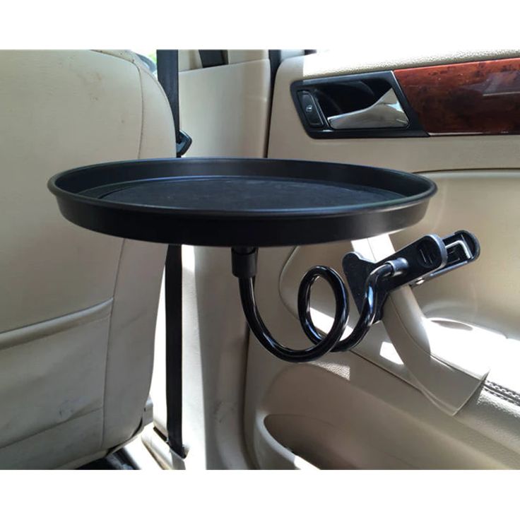 a black tray sitting in the back seat of a car next to a steering wheel